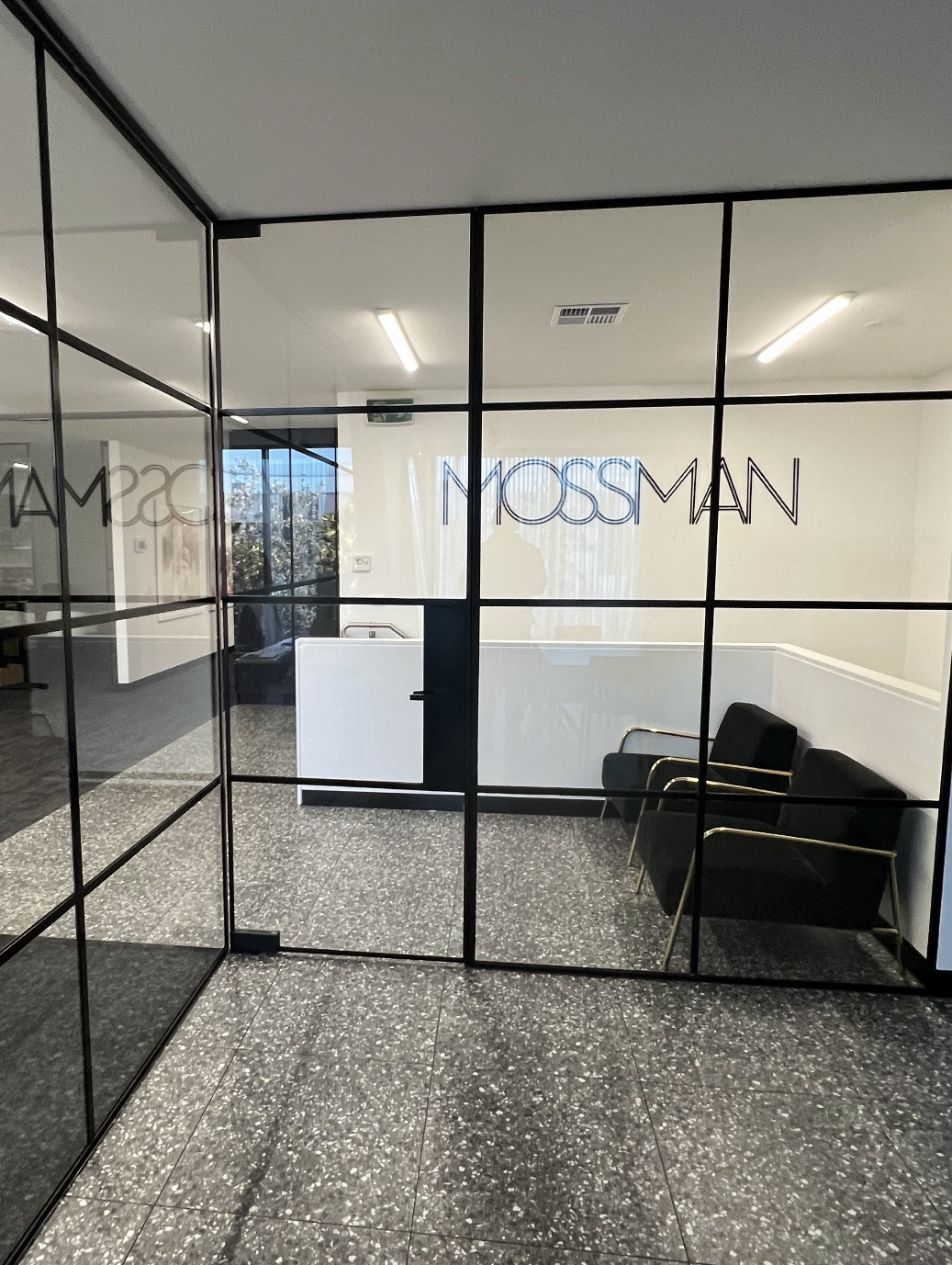 Black-framed glass partitions and a door around a reception area