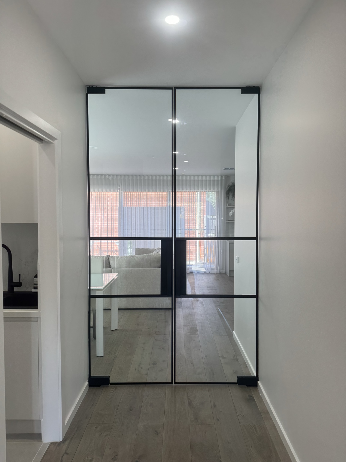 Closed black double glass doors across an internal hallway