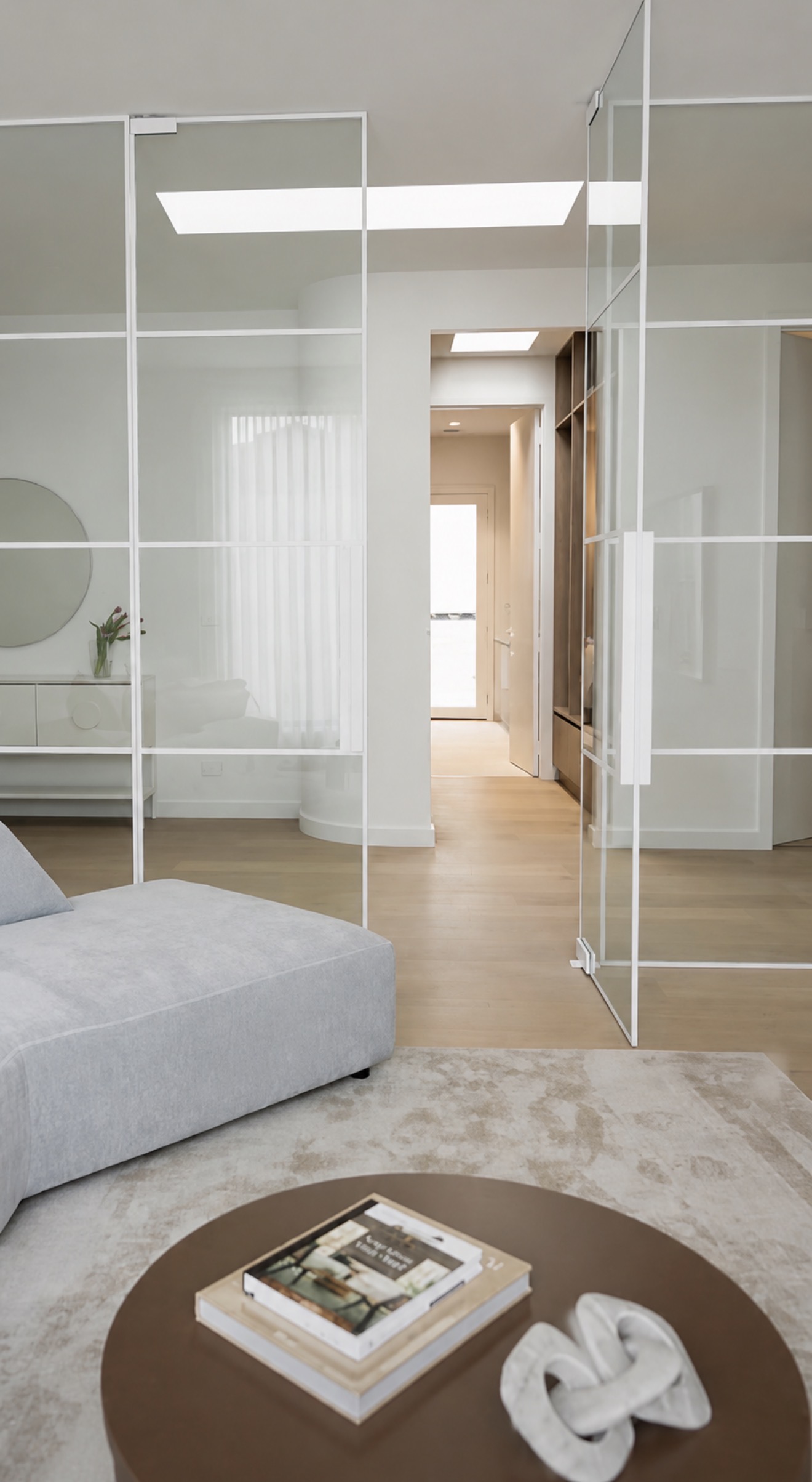 White Boutique Series glass doors open between a living room and hallway