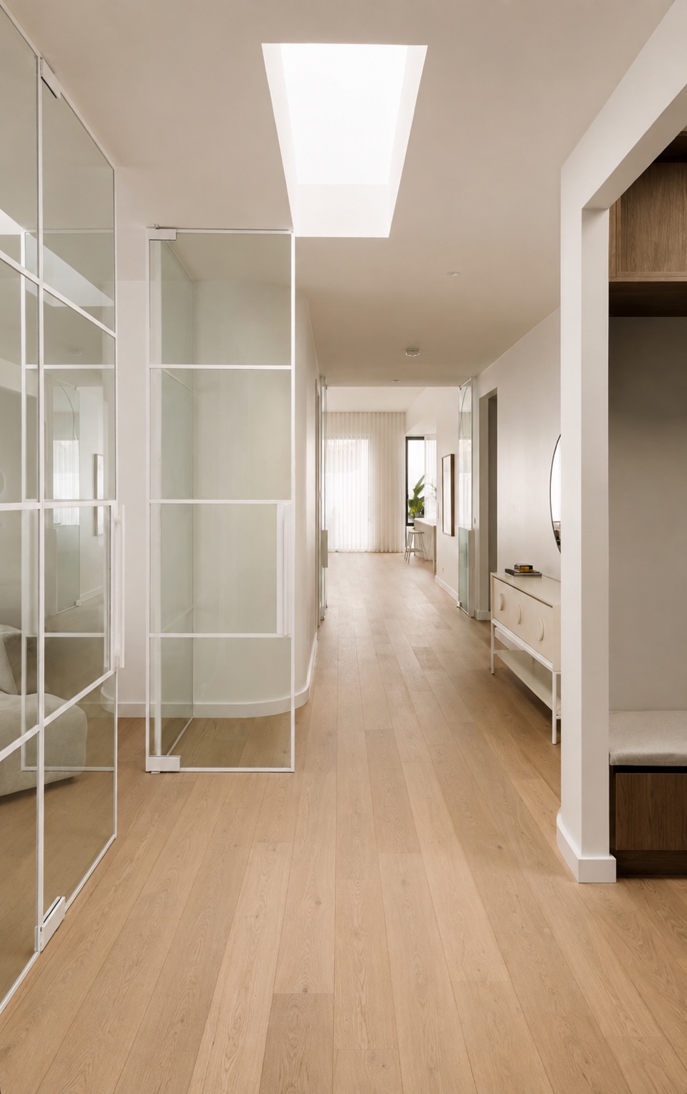 Open white glass door and glazed panels along a timber-floored hallway