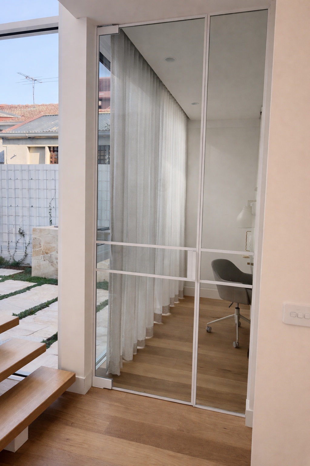 White-framed clear glass study door beside timber stairs and sheer curtains
