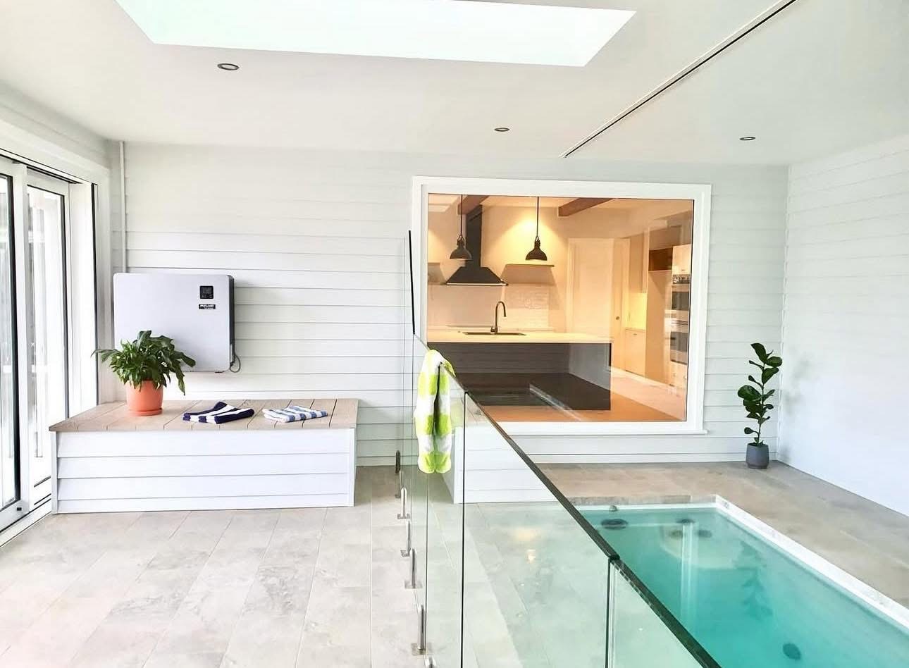 Glass fence beside an indoor pool beneath a skylight