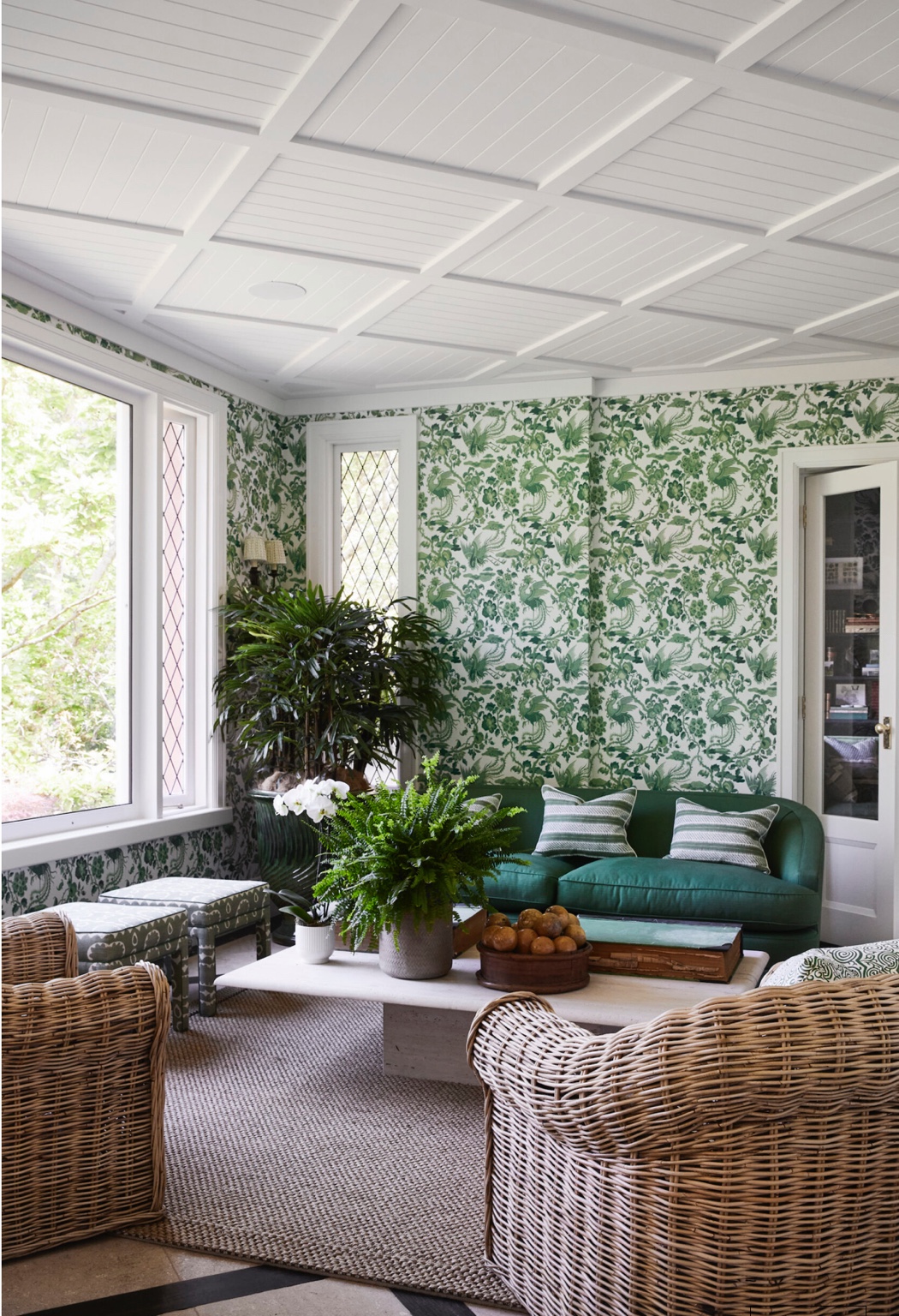 White-framed windows in a sitting room with green wallpaper and a green sofa